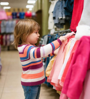 Kind schaut Klamotten an